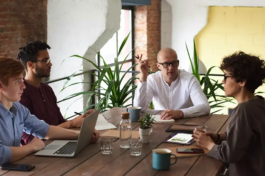 Professionals in a meeting around a conference table discussing business plans