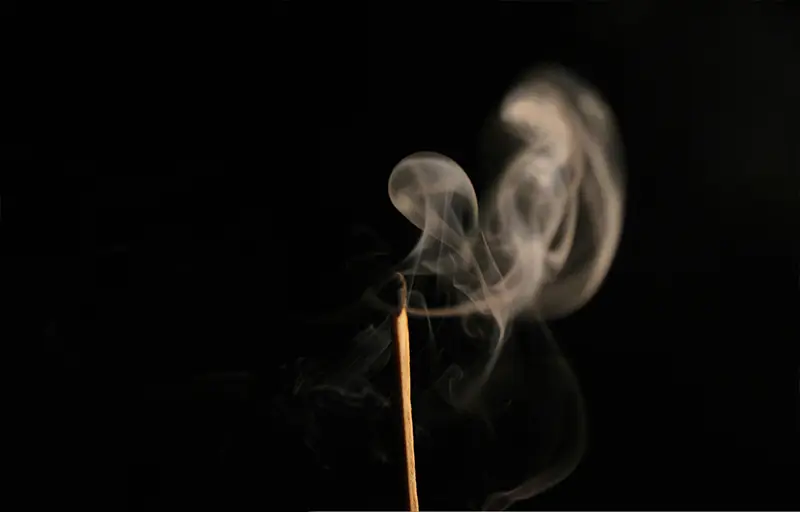 A burnt matchstick releasing soft spirals of smoke into a dark background, symbolising a fading spark in sales motivation